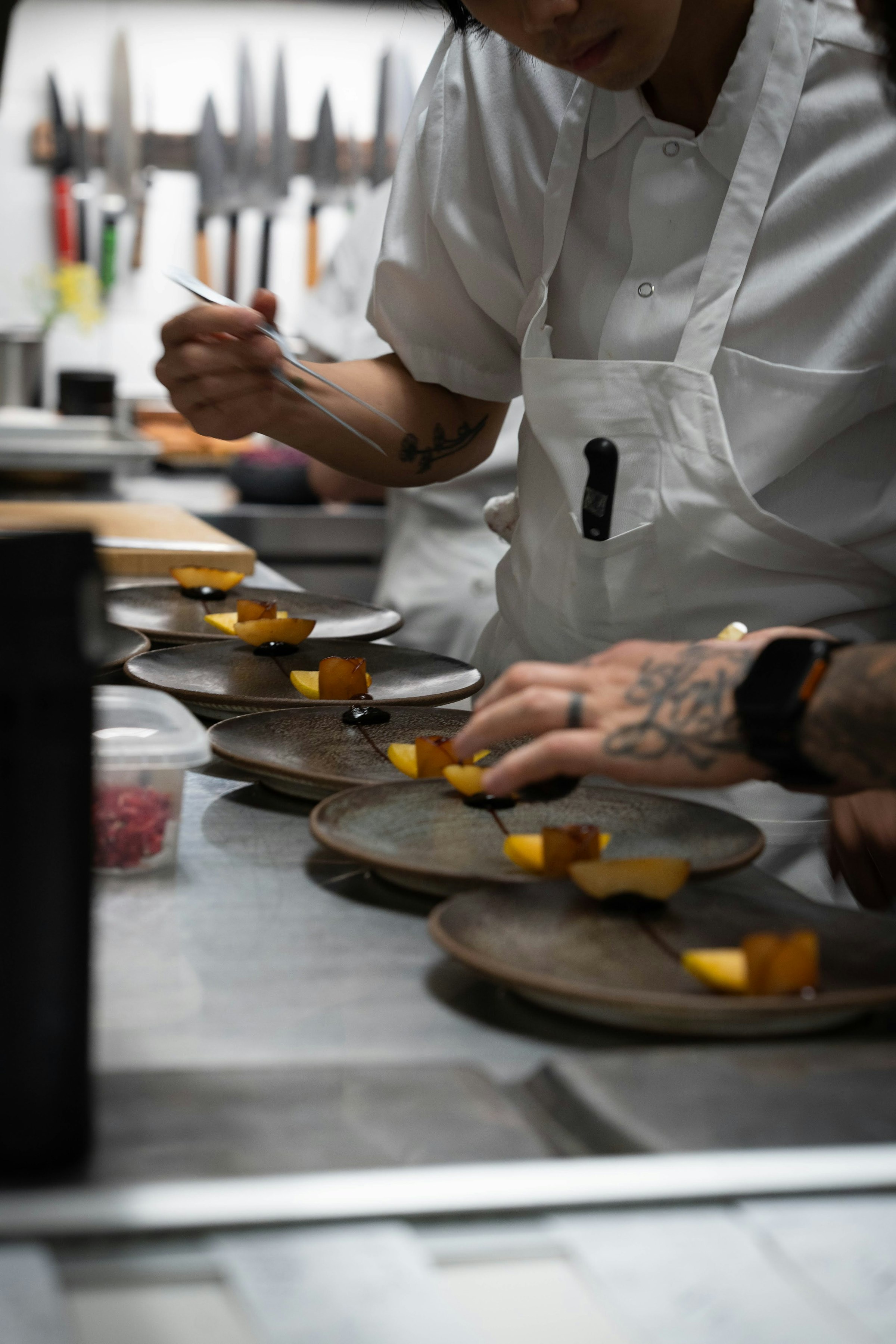 Chef plating a dish with precision in a professional kitchen